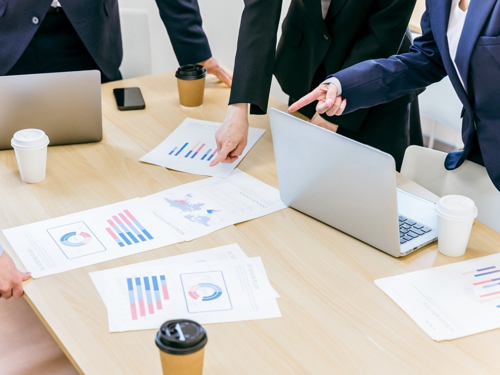 資料を指差す人々